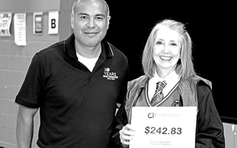 Simsteacher,AngelMoore,receivesagrantfromBeccaBell JoseRodriguezprovidesWallaceteacher,LindaTraughber,a grant for laptop chargers