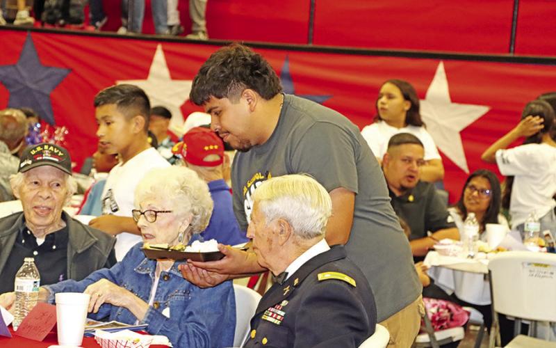 MPHS senior, Amir Martinez, serves lunch to the guests