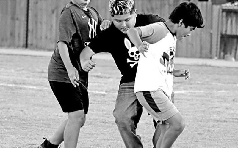 Aaron Garcia, Rene Cruz, and Caleb Romero play soccer