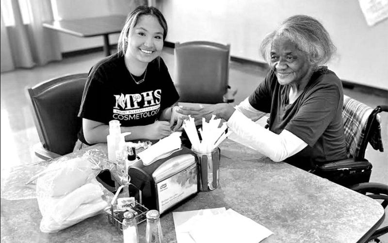 Raquel Martinez (left) gives Velma Hurd a manicure