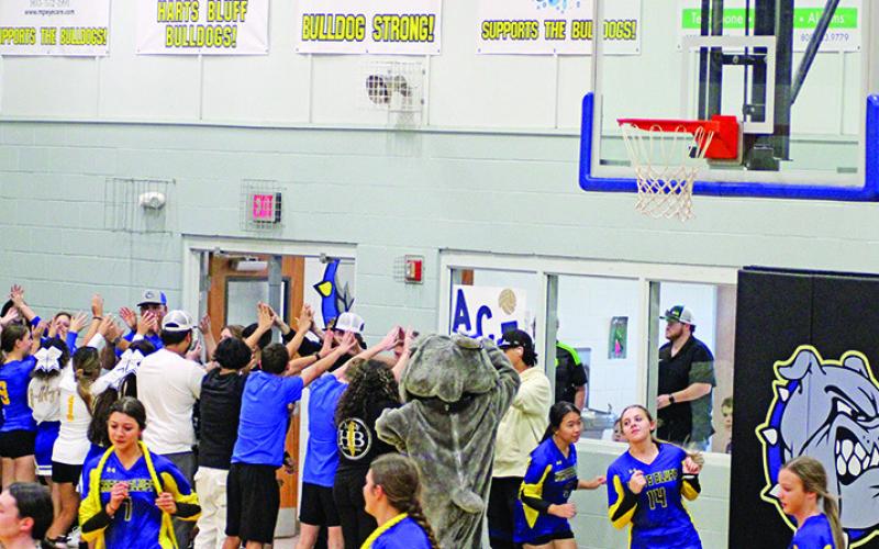 The Harts Bluff Lady Bulldogs enter the court through a tunnel of cheerleaders, fellow students and fans for the first time as part of a UIL district.