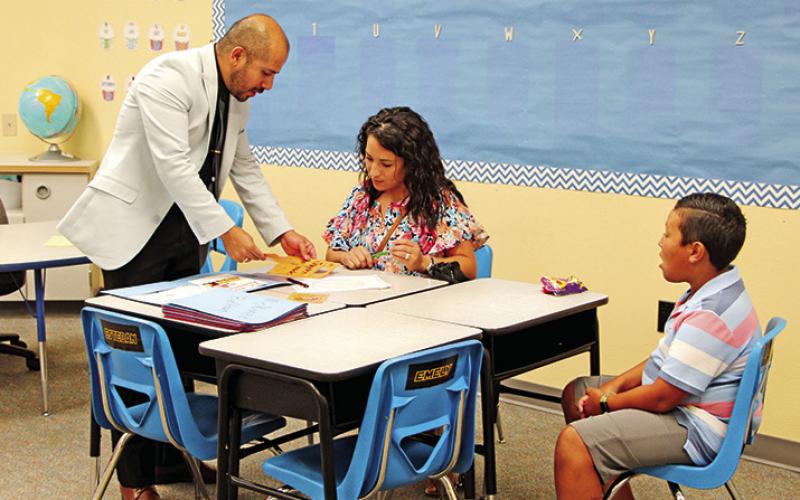 Mr. Vera from E.C. Brice helps a student and parent get registered for class.