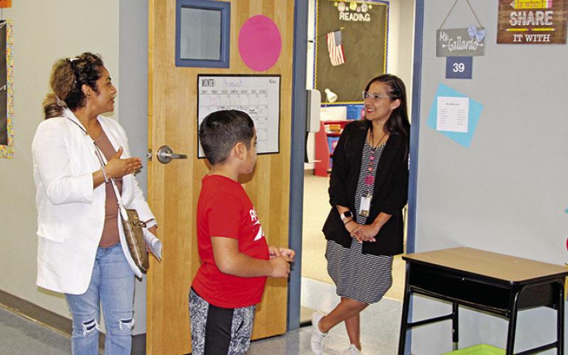 Fowler teacher, Evelyn Gallardo, visits with a student and parent