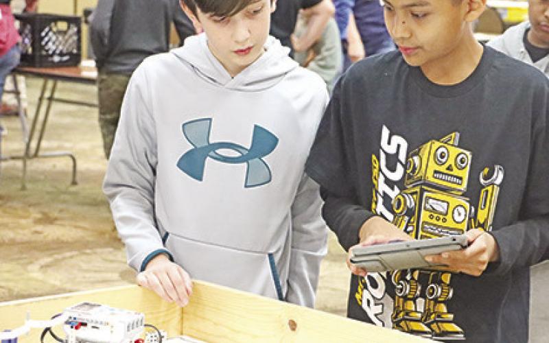 The Terminators drive their robot using an iPad. Wallace Team 2 drives their robot and attempts to pick up nerf bullets.