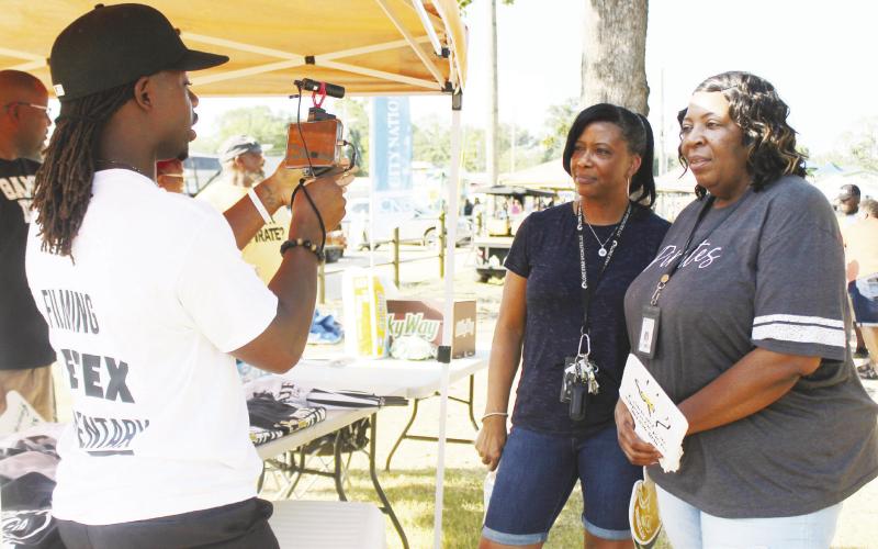 Kaymon Farmer videos two ladies during the annual Tailgate Party in Pittsburg and asks them what makes Friday Night Lights special to them personally. GAZETTE PHOTO / ELIZABETH LANNING