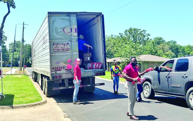 Pilgrim’s Pride employees set up at Oaklawn Park Friday to for a community product giveaway; each vehicle that arrived was able to receive one bag of product. COURTESY PHOTO