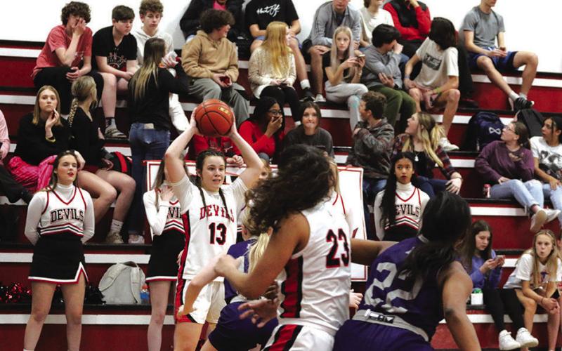 Katie Hart looks to make a pass while Mackenzie Espinosa battles for position in the paint. The Chapel Hill Lady Devils opened their playoff run Monday evening against Hooks where they earned a 59-27 win and a Bi-District Championship. PHOTO BY QUINTEN BOYD