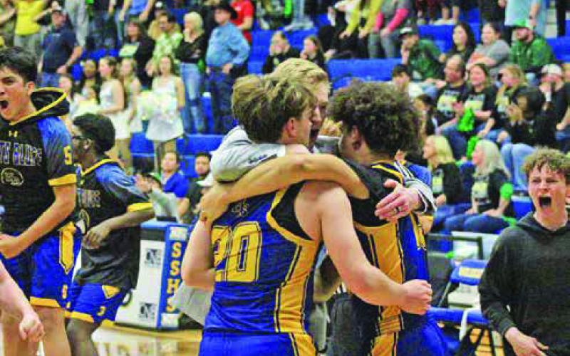 Harts Bluff head coach Bradley Lambeth embraces Kayden Mason and Cayden James as the Bulldogs celebrate their first-ever playoff win as the Bulldogs won their bi-district round matchup over Quinlan Boles in overtime, 81-78. TRIBUNE PHOTOS / QUINTEN BOYD