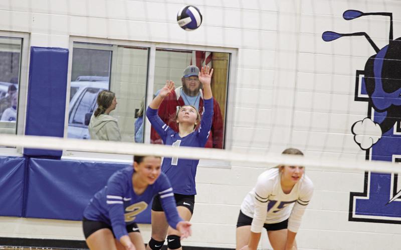 Pewitt’s Avery Perry prepares to serve while Ashtyn Boyd (left) and Natalie Cobb (right) get in position during Friday’s district playoff against Queen City. The Lady Bulldogs won the match, 3-1. Pewitt’s volleyball season ends at 20-12. TRIBUNE PHOTO / QUINTEN BOYD