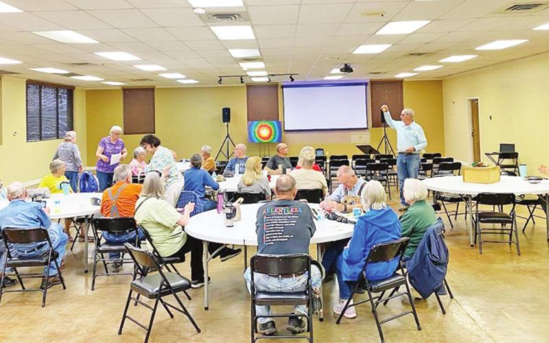A group of volunteers pause together before their workday begins to have a Bible study earlier this week. COURTESY PHOTO