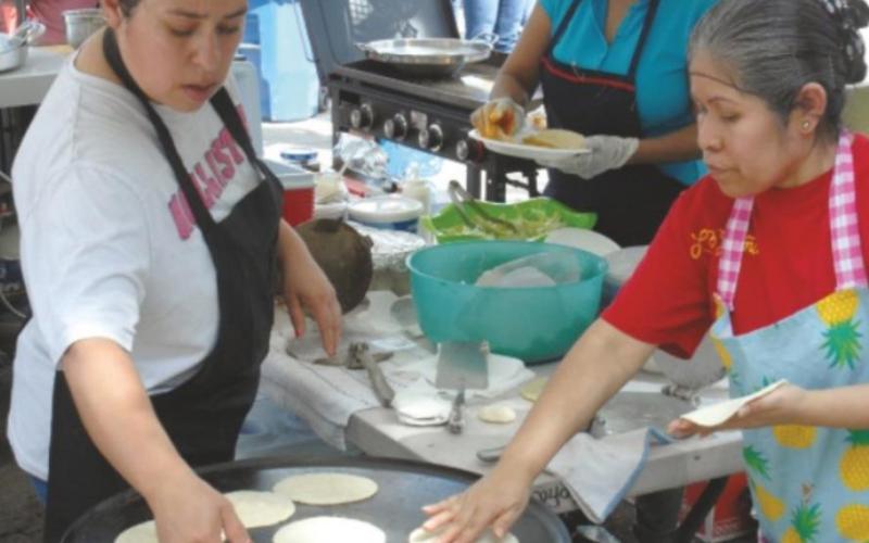 Cooks work together at a vendor at the 2019 Cinco de Mayo celebration. TRIBUNE FILE P HOTO