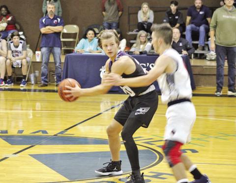CHAAMP’s John Luke Angier holds the ball with his back to an approaching Kings Academy defender. COURTESY PHOTO
