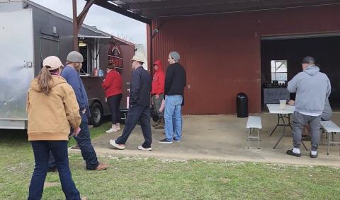 Guests wait in line at a food truck.