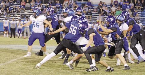 Rivercrest’s Noah Altal (#56), Connor Herring (#10) and Dalton Lovett (#22) corral a Wolfe City running back during Thursday’s game. The Rebels will take on Beckville in the bi-district round of the playoffs next week. TRIBUNE PHOTO / QUINTEN BOYD