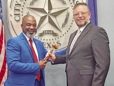 Tracy Craig hands over the gavel to Wesley Lyon as welcome of the new mayor TRIBUNE PHOTO / NICOLE KIMBALL