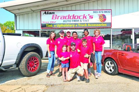 The Braddock’s family stands in front of their auto business of 63 years