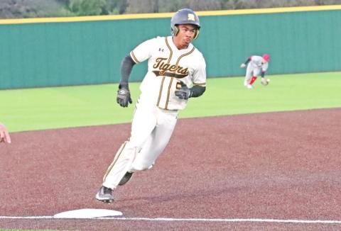 Tyson Minter rounds third trying to beat the throw from center.