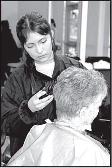 JenniferPenaputsfinishingtouchesonacustomer’shaircut