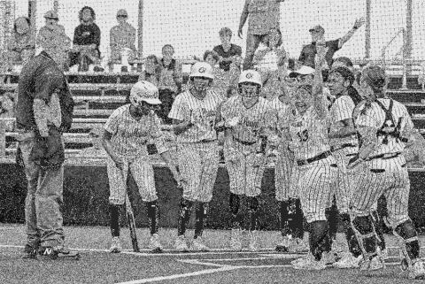 Her teammates wait at home plate to celebrate Rayleigh White’s three-run homerun.