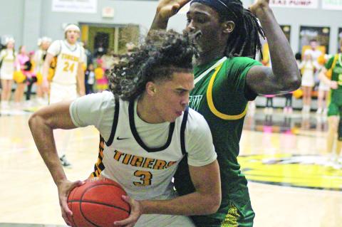 Mount Pleasant’s Kai Price battles with Longview’s Robert Blandburg during Tuesday’s game. The Tigers fell just short against the Lobos, 45-42. Mount Pleasant hosted Marshall Friday and travel to Tyler for their regular season finale Tuesday. TRIBUNE PHOTO / QUINTEN BOYD