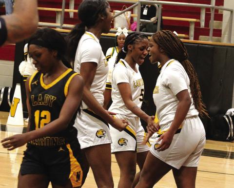 From left, Mount Pleasant’s Aziyah Farrier, Kendall Walker and Jordyn Hargrave celebrate after a layup by Hargrave during Monday’s playoff game against Nacogdoches. The Lady Tigers won, 82-44, and will meet Crandall in the area round this weekend. PHOTO BY QUINTEN BOYD