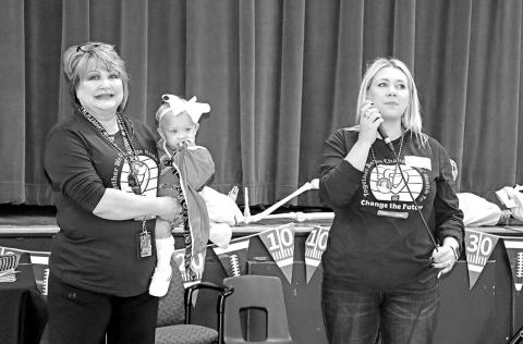 Cari Crooks Onellion (right) speaks to the students at Corprew while Karen Crooks (left) holds granddaughter, Scottie B.