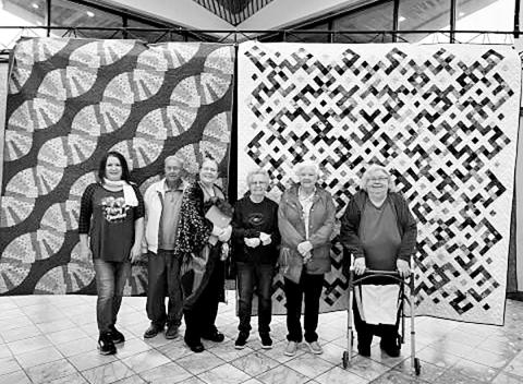 Dr. Karyn Skaar with her daughter, Solveig, in front of the two quilts she displayed in the exhibit. COURTESY PHOTO