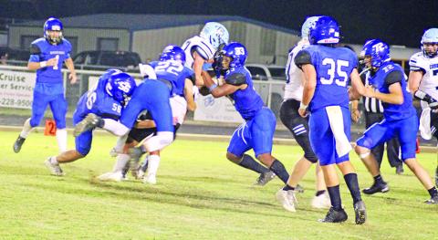 From left, Noah Altal, Dalton Lovett and JaQuan Brown combine to bring down a ball carrier during a recent game. The Rebels will meet Honey Grove Friday at The Swamp. TRIBUNE PHOTO / QUINTEN BOYD