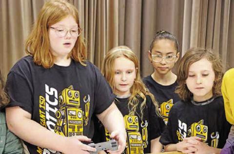 Aryana Knieriem (left) of the Corprew Titans guides their robot with the controller while teammates (L to R) Nylah Bell, Valeria Palacios, and Jace Kline look on.