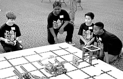 Wallace Team 2 member Samuel Erickstad (left) attempts to capture the ball as (L to R) Karter Fields, Joshuah Antonio, and Kaiden Barber cheer him on