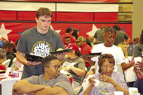 MPHS senior, Tanner Marshall (left), and Wallace fifth grader, Carmelo Green, serve the veterans and their families