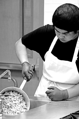 Kurt Alipao prepares the homemade macaroni and cheese