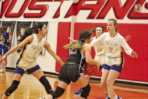 From left, Harts Bluff’s Alexa Arzate, Kaitley Green and Kaylee Clay defend Como-Pickton’s Bella Romero during Monday’s playoff game. The Lady Bulldogs fell in the program’s first ever basketball playoff game but return eight of their nine players next season in the hopes of returning to the playoffs. TRIBUNE PHOTO / QUINTEN BOYD