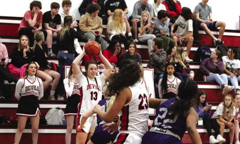 Katie Hart looks to make a pass while Mackenzie Espinosa battles for position in the paint. The Chapel Hill Lady Devils opened their playoff run Monday evening against Hooks where they earned a 59-27 win and a Bi-District Championship. PHOTO BY QUINTEN BOYD